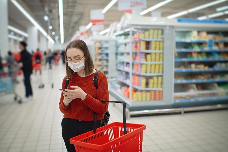 woman shopper reads Heart-Check certified product list while shopping
