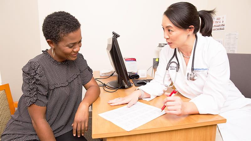Doctor reviewing lab work with patient at her desk