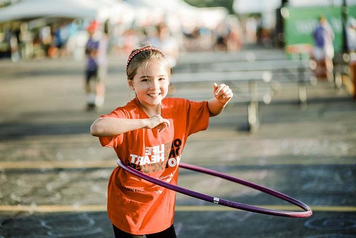 Little girl hula hooping at Heart Walk event